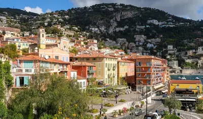 a view of a city with buildings and a mountain at Charmant studio rénové – Place de la République in Villefranche-sur-Mer