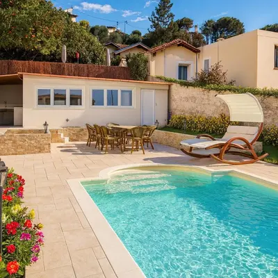 a house with a swimming pool and a table and chairs at Studio de la Villa Thérèse, Piscine & Jardin in Saint-Laurent-du-Var