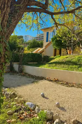 a yard with rocks on the ground next to a house at Studio de la Villa Thérèse, Piscine & Jardin in Saint-Laurent-du-Var