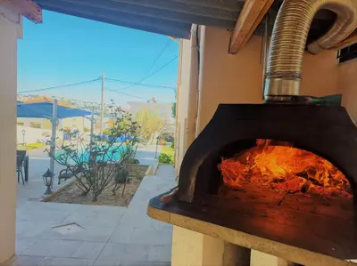 a pizza oven with a fire inside of it at Studio de la Villa Thérèse, Piscine & Jardin in Saint-Laurent-du-Var