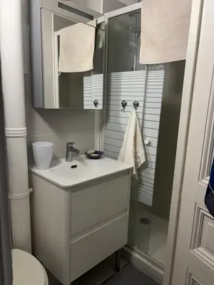 a white bathroom with a sink and a shower at 3 pièces lumineuses, 3 nuitées minimum in Nice