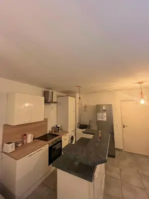 a kitchen with white cabinets and a black counter top at riviera in Nice