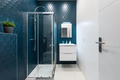 a glass shower in a bathroom with blue tiles at 1 CASSINI LOT 5 - Magnifique Studio - Garibaldi - Port in Nice