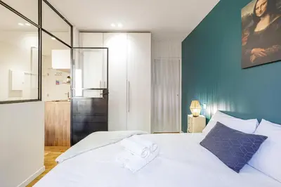 a bedroom with a white bed with a blue wall at 1 GALLO LOT 3 - Joli appartement au coeur du Vieux-Nice - AC in Nice