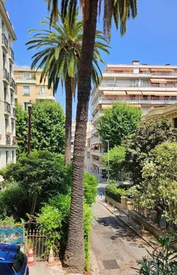 a palm tree in front of a building at Nice 2-room apartment off the beach in Nice