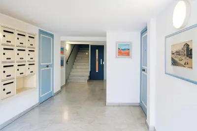 a hallway with blue doors and a staircase at Beach Studio on Cagnes sea front in Cagnes-sur-Mer