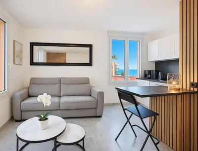 a living room with a couch and a table at Beach Studio on Cagnes sea front in Cagnes-sur-Mer