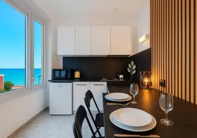 a kitchen with a table and chairs and a kitchen with the ocean at Beach Studio on Cagnes sea front in Cagnes-sur-Mer