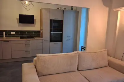 a living room with a couch and a kitchen at Charming bright apartment in Nice in Nice