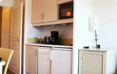 a kitchen with white cabinets and a microwave at Mer et Soleil in Villefranche-sur-Mer