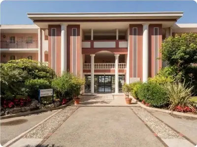 a large pink building with trees and bushes at Mer et Soleil in Villefranche-sur-Mer