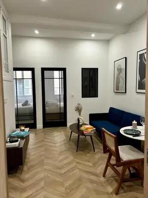 a living room with a blue couch and a table at Luxueux Logement à 2 pas de la mer, Vieille ville in Nice