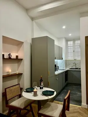 a kitchen with a table and chairs in a room at Luxueux Logement à 2 pas de la mer, Vieille ville in Nice