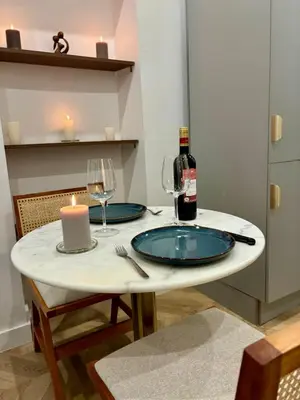a table with a candle and a bottle of wine at Luxueux Logement à 2 pas de la mer, Vieille ville in Nice