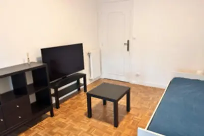 a living room with a flat screen tv and a table at Studio with veranda 5min walk to the beach in Nice