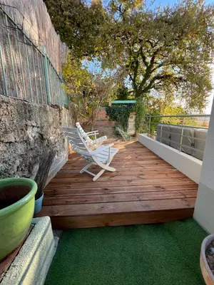 a wooden deck with two chairs on top of it at Golden hours luxury and panoramic view in Nice