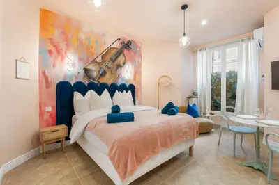 a bedroom with a violin painting on the wall at Cocon stylé Centre et mer à pied CLIM WIFI in Nice