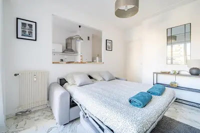a bedroom with a bed with blue pillows on it at Port de Nice - Studio with balcony in Nice