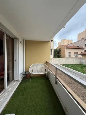 a bench sitting on a balcony with green grass at AZUR DELUXE Nice in Nice