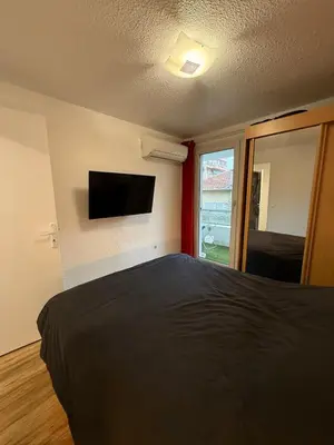 a bedroom with a bed and a flat screen tv at AZUR DELUXE Nice in Nice