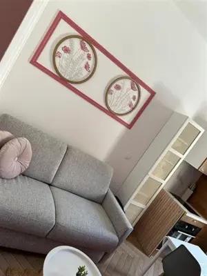 a living room with a couch and two clocks on the wall at MOON 23 - Appartement Nice 2P in Nice