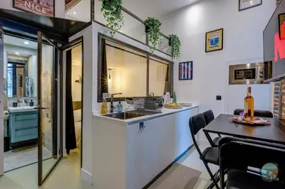 a kitchen with a sink and a table with a bottle of wine at Chic Industrial Loft Quiet Garibaldi AC Balcony in Nice