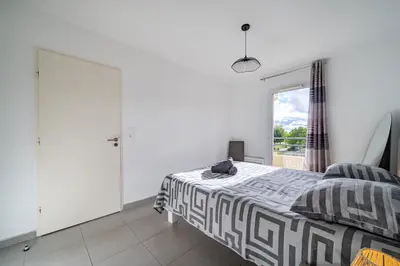 a bedroom with a bed and a window at Superbe 2 pièces - Piscine et garage in Nice