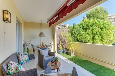a patio with two blue chairs and a table at IMPERIA AP4490 by RIVIERA HOLIDAY HOMES in Nice