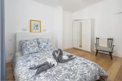 a bedroom with a bed with a blanket and a chair at Quartier Libération - La Vie à la Niçoise in Nice