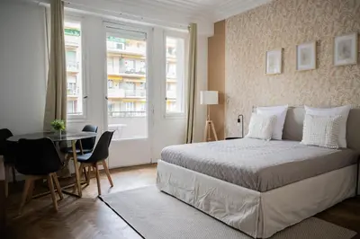 a bedroom with a bed and a table and a window at Appartement-Suite neuf - 2 chambres - 1 min mer in Nice