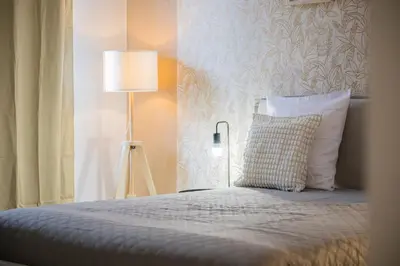 a bedroom with a bed with a pillow and a lamp at Appartement-Suite neuf - 2 chambres - 1 min mer in Nice