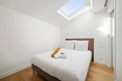 a white bed in a room with a window at Emplacement exceptionnel Deux Chambres AC WIFI in Nice
