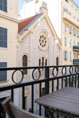 a balcony with a table and a building at T3 résidence neuve Centre-Ville 6 Couchages in Nice