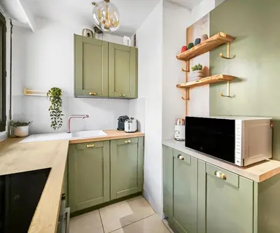 a kitchen with green cabinets and a microwave at Central, élégant & cosy in Nice
