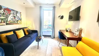 a living room with a blue couch and a table at Studio design et lumineux près du Port de Nice in Nice