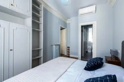a bedroom with a bed with blue walls and shelves at La Suite Londres in Nice