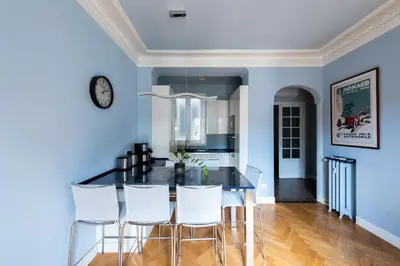 a dining room with a black table and white chairs at La Suite Londres in Nice
