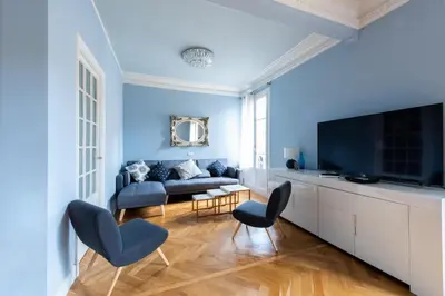 a blue living room with a couch and a tv at La Suite Londres in Nice