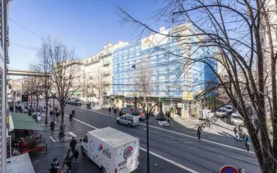 a busy city street with a large glass building at Appartement 2 chambres Nice Jean Medecin in Nice
