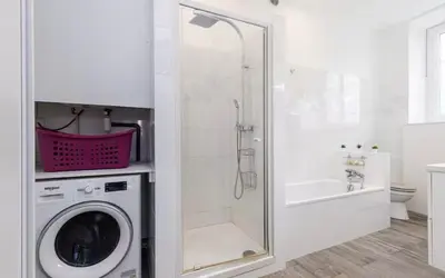 a white bathroom with a washing machine and a shower at Appartement 2 chambres Nice Jean Medecin in Nice