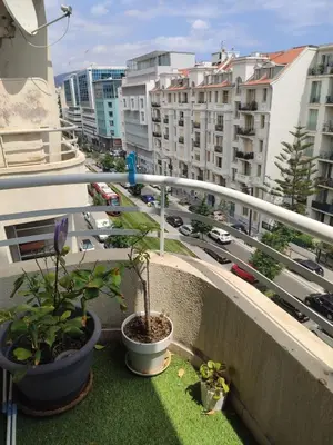 a balcony with potted plants and a view of a city at Beautiful studio apartment just a stone's throw from the beach in Nice