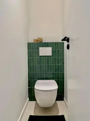 a green tiled bathroom with a white toilet at Un cocon en centre ville de Nice 2 personnes in Nice