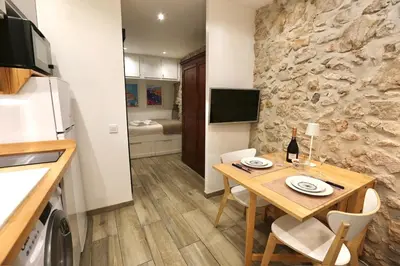 a small kitchen with a table and a refrigerator at Studio de charme - Vieille Ville - Proche plage in Villefranche-sur-Mer