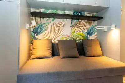 a bench with pillows on it in a room at Victoria 2 People Parking AC WiFi in Nice