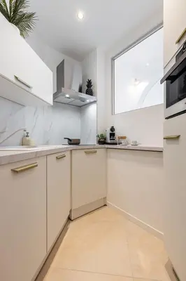 a kitchen with white cabinets and a window at MY CASA - VERDI - Superb Studio Suite City Center in Nice