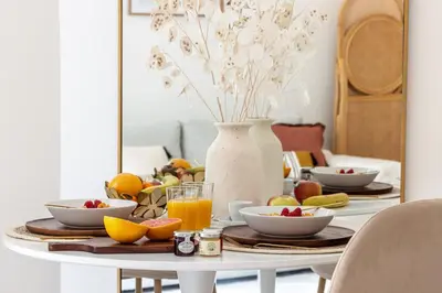 a table with bowls of fruit and a vase of flowers at MY CASA - VERDI - Superb Studio Suite City Center in Nice