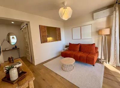 a living room with a couch and a table at Studio cosy - Vue mer - Terrasse - Parking in Saint-Laurent-du-Var