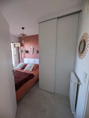 a bedroom with a bed and a large sliding door at T2 douillet proche de Nice - Accès plage à pied in Cagnes-sur-Mer