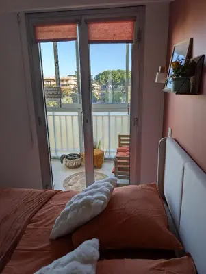 a bedroom with a bed with a view of a balcony at T2 douillet proche de Nice - Accès plage à pied in Cagnes-sur-Mer