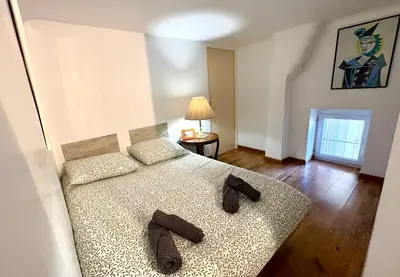 a bedroom with a bed with two slippers on it at Parenthèse Niçoise - Cœur de Nice in Nice
